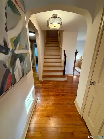 a view of entryway and hall with wooden floor