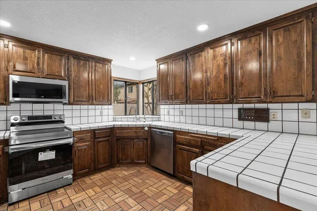 a spacious bathroom with a granite countertop tub a double vanity sink a two mirror a lamp a bathtub and vanity