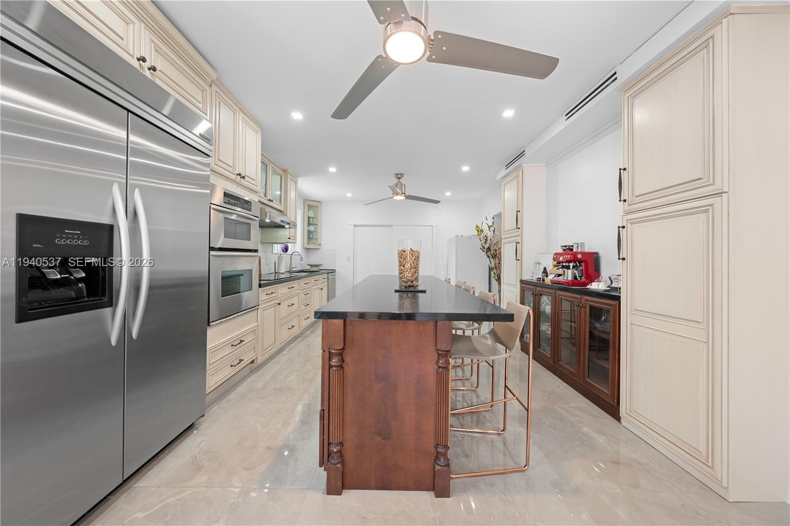 6423 Southwest 107th Place Miami, FL 33173 - Photo 17 of 37 a kitchen with stainless steel appliances kitchen island granite countertop a refrigerator and a sink