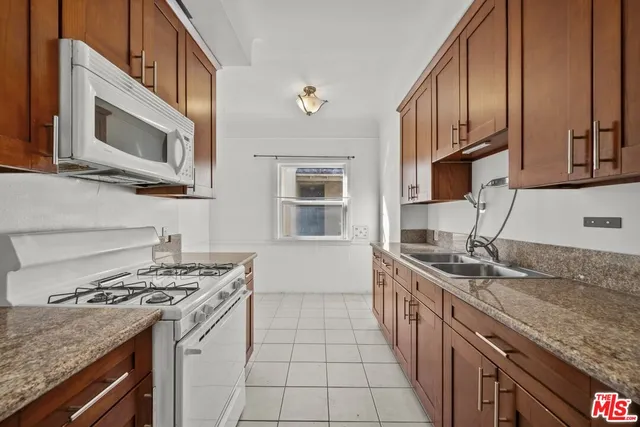 a kitchen with a sink stove top oven and cabinets