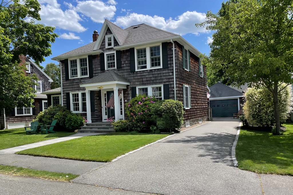 a front view of a house with a yard and trees