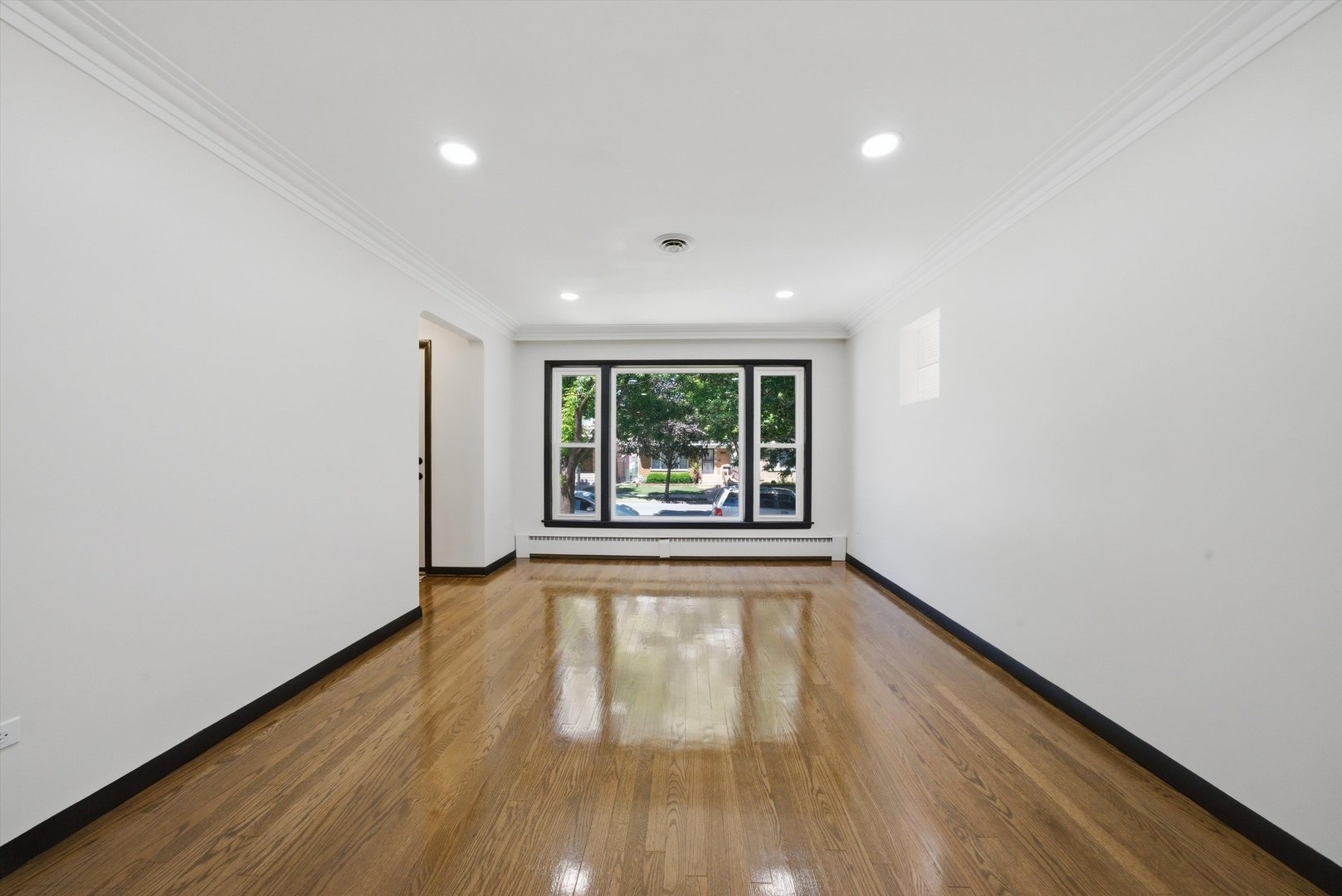 3907 West Marquette Road Chicago, IL 60629 - Photo 3 of 32 a view of an empty room with wooden floor and a window