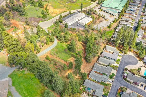 an aerial view of residential house with outdoor space and trees all around