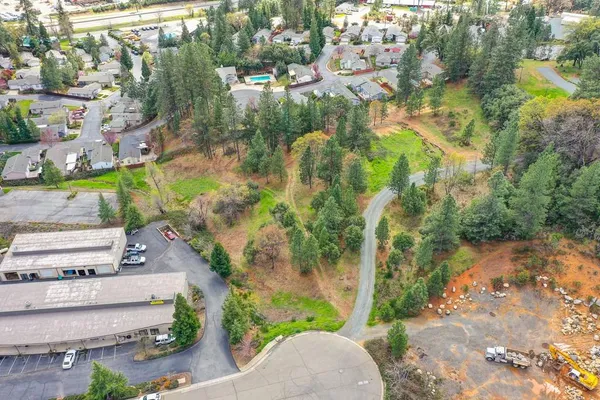 an aerial view of residential house with outdoor space and trees all around