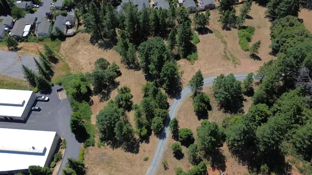 an aerial view of residential house with outdoor space and trees all around