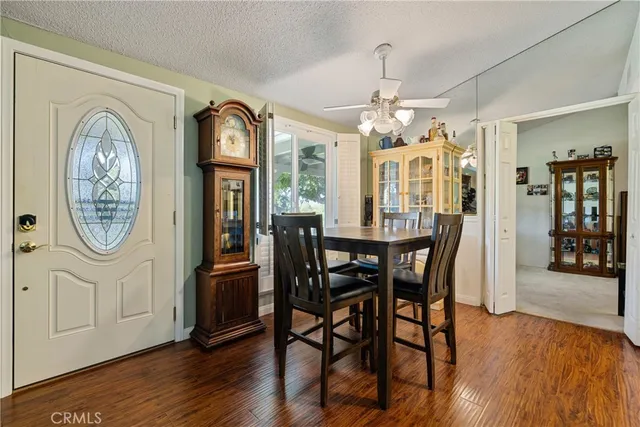 a view of a dining room with furniture a chandelier and wooden floor