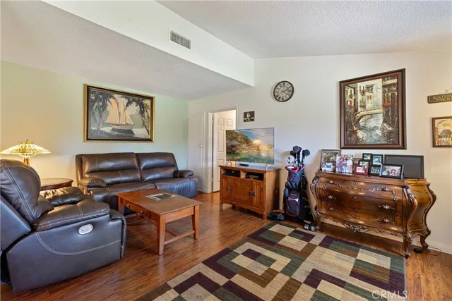 a living room with furniture a wooden floor and next to a window