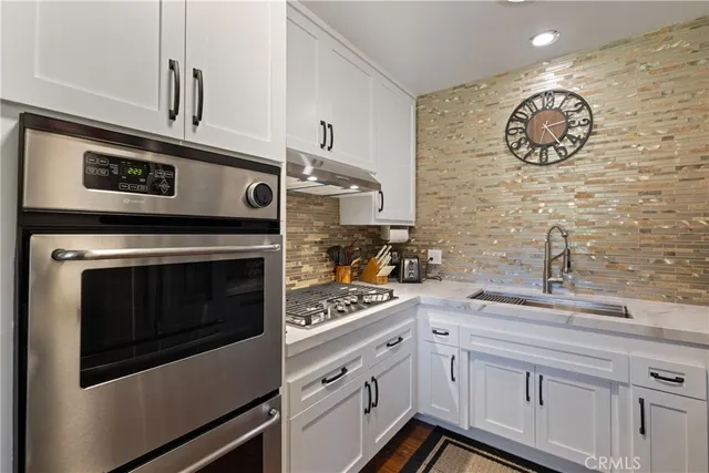a kitchen with stainless steel appliances a refrigerator and a stove top oven