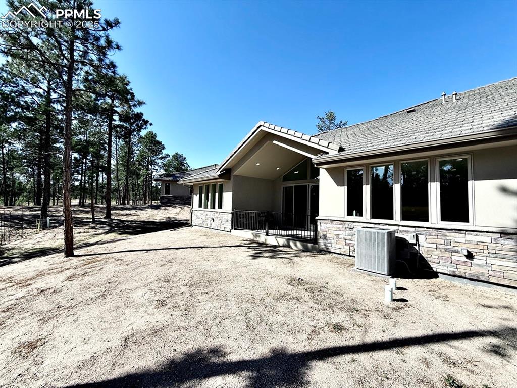3135 Promise Point Colorado Springs, CO 80921 - Photo 28 of 33 Rear view of house with stone siding, stucco siding, and a patio area
