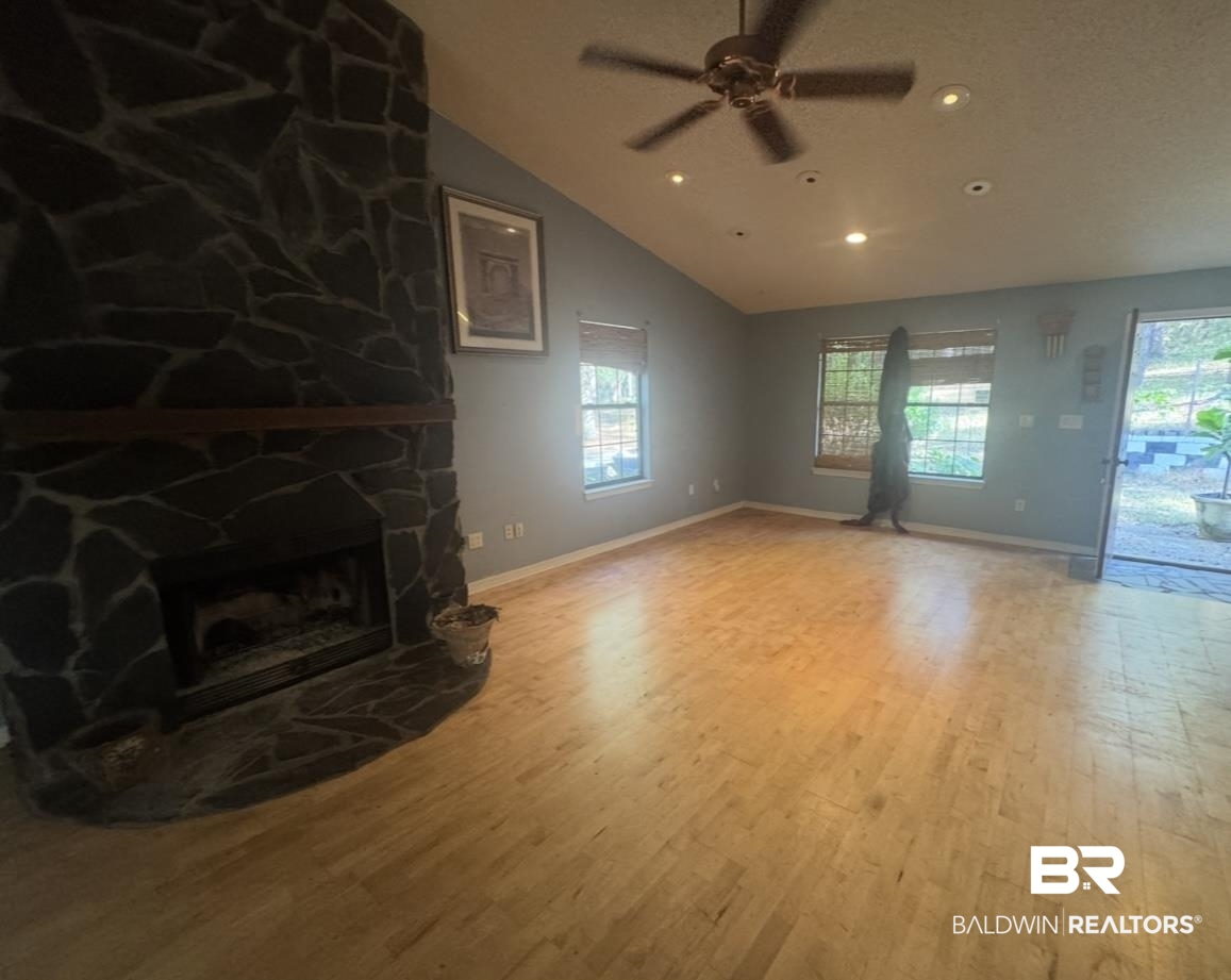 23341 County Road 49 Silverhill, AL 36576 - Photo 12 of 23 Unfurnished living room with a fireplace, light wood-style floors, vaulted ceiling, recessed lighting, and ceiling fan