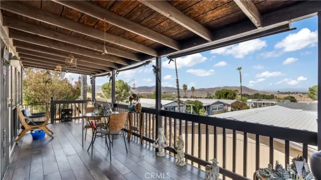 a view of a balcony with chairs and wooden floor