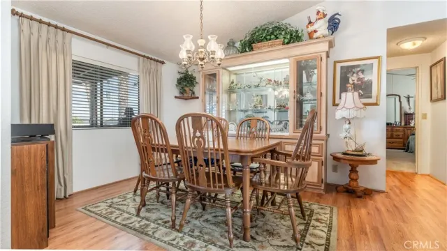 a view of a dining room with furniture a chandelier and wooden floor