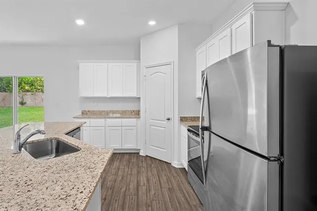 a kitchen with a refrigerator sink and cabinets