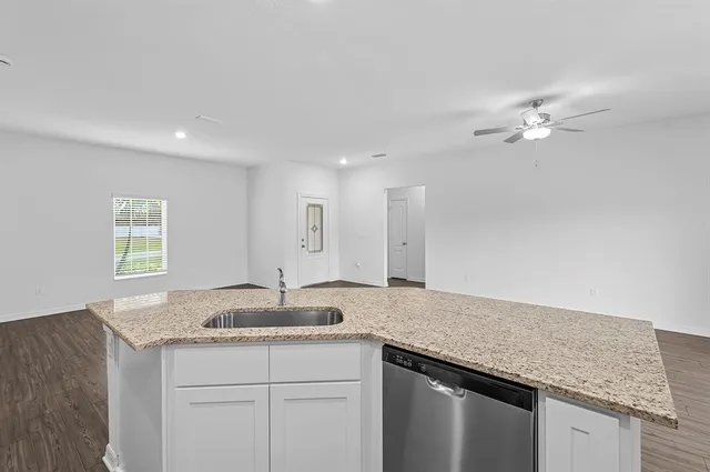 a bathroom with a granite countertop sink a mirror and a shower