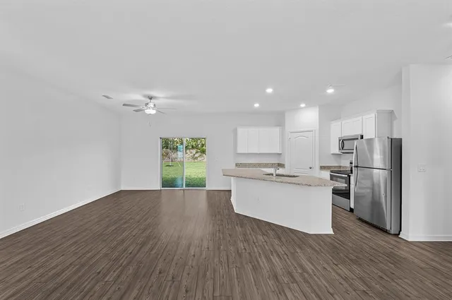 a kitchen with a refrigerator and white cabinets