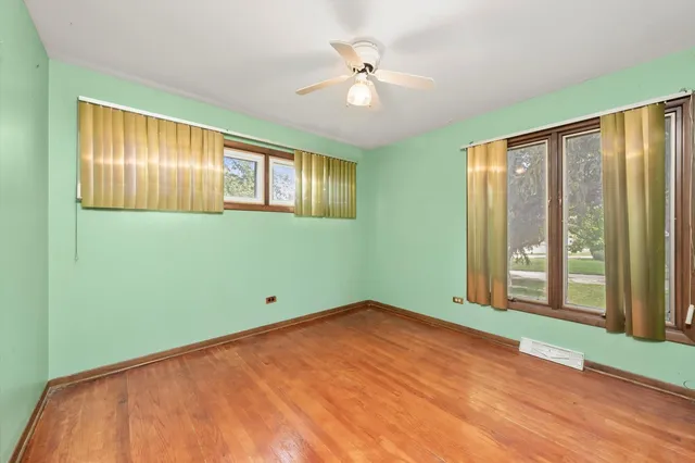 a view of an empty room with a window and a ceiling fan