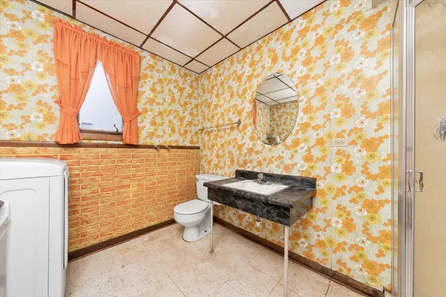 a bathroom with a toilet a sink and a shower curtain