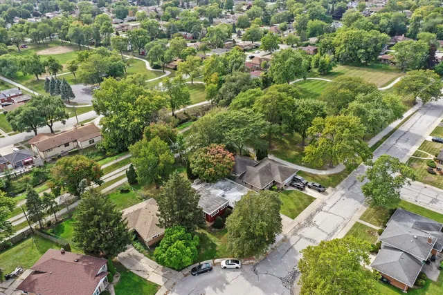 an aerial view of residential house with outdoor space and trees all around
