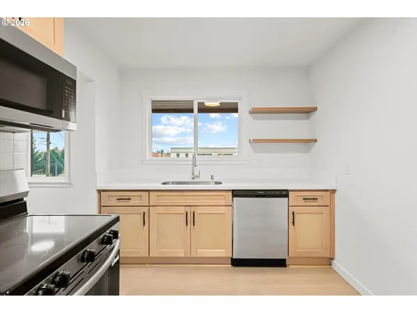 a kitchen with stainless steel appliances granite countertop a sink and a stove