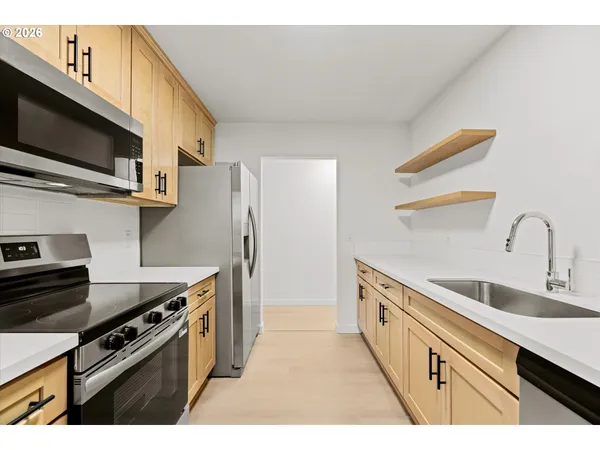 a kitchen with stainless steel appliances a sink a stove and a microwave