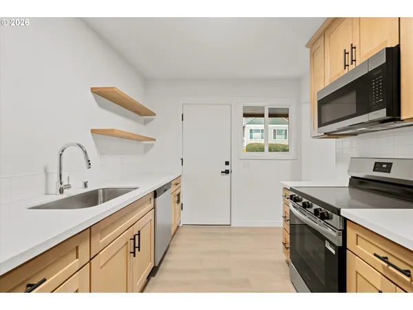 a kitchen with stainless steel appliances a sink a stove and microwave