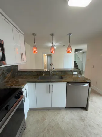 a kitchen with granite countertop a sink and cabinets