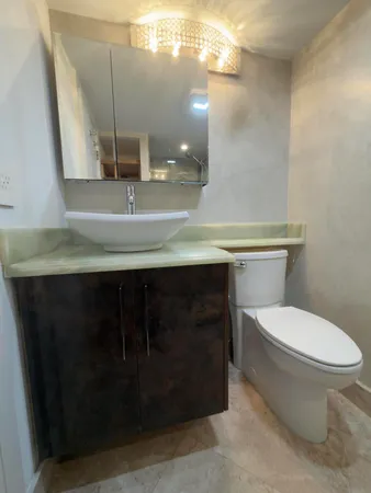 a bathroom with a toilet a sink and mirror