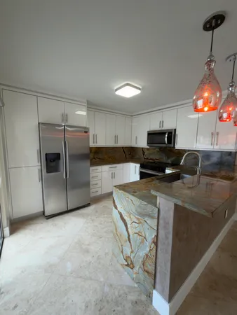 a kitchen with stainless steel appliances granite countertop a refrigerator a stove a sink and a microwave