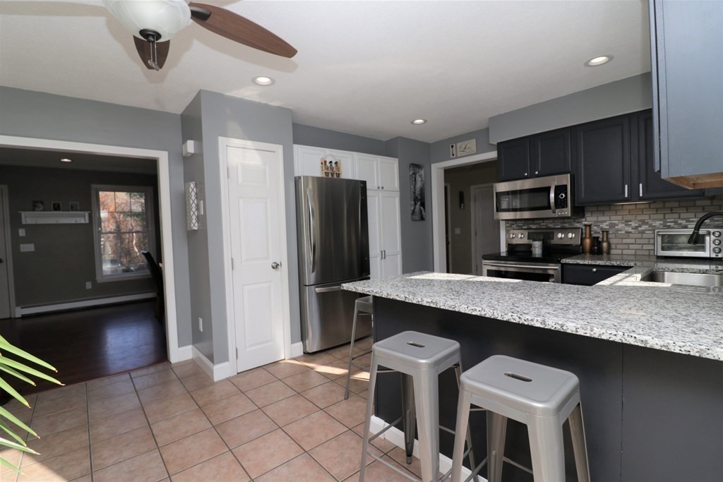 389 County Road Ashby, MA 01431 - Photo 9 of 34 a kitchen with stainless steel appliances granite countertop a refrigerator a stove a sink and a microwave