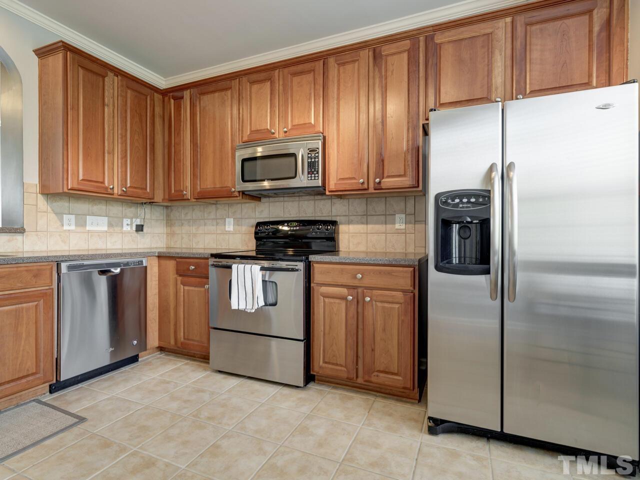 7608 Winners Edge Street Raleigh, NC 27617 - Photo 14 of 38 a kitchen with stainless steel appliances granite countertop a refrigerator a stove a sink and dishwasher