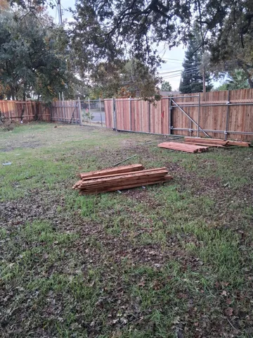 a view of backyard with wooden fence