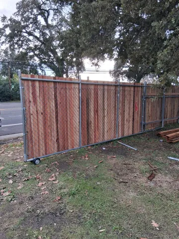 a view of wooden fence with trees in the background