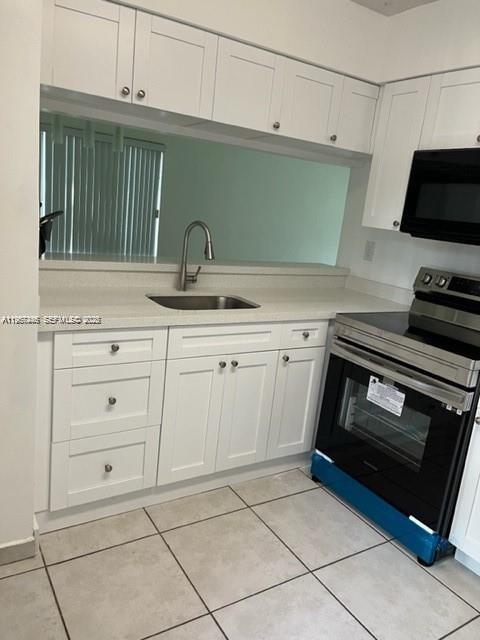 14020 Southwest 90th Terrace, Unit 14020 Miami, FL 33186 - Photo 13 of 13 a kitchen with white cabinets and appliances