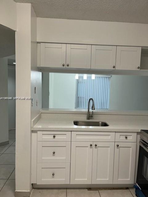 14020 Southwest 90th Terrace, Unit 14020 Miami, FL 33186 - Photo 3 of 13 a kitchen with white cabinets and a sink