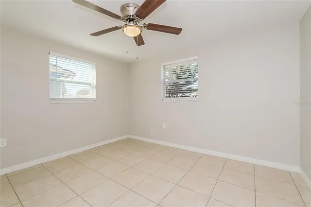 an empty room with a window and a fan