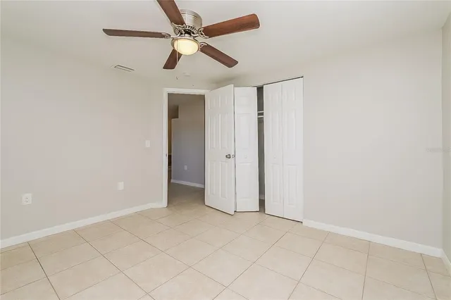 an empty room with a window and a fan