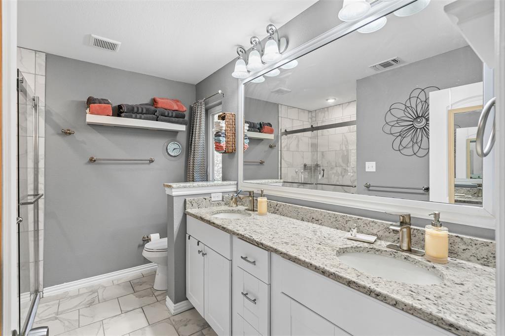 905 Poe Street Azle, TX 76020 - Photo 19 of 30 a bathroom with a granite countertop sink a toilet and a mirror
