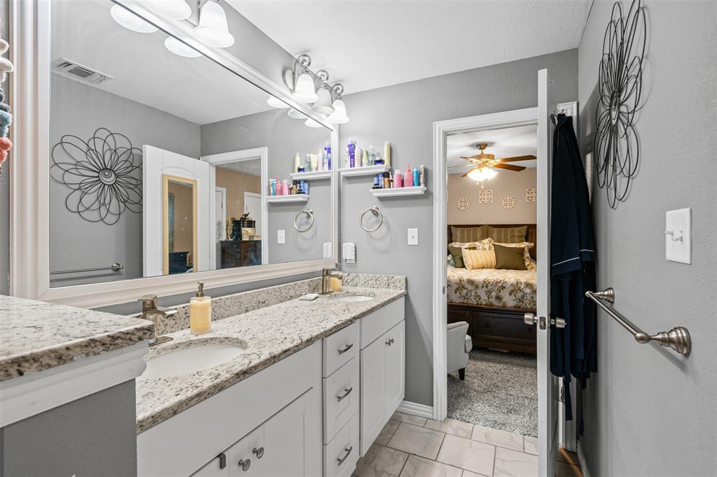 905 Poe Street Azle, TX 76020 - Photo 21 of 30 a spacious bathroom with a granite countertop sink and a mirror