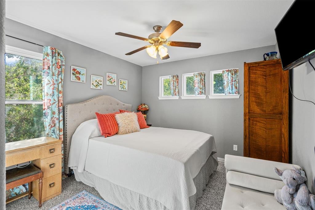 905 Poe Street Azle, TX 76020 - Photo 22 of 30 a bedroom with a bed and a flat screen tv