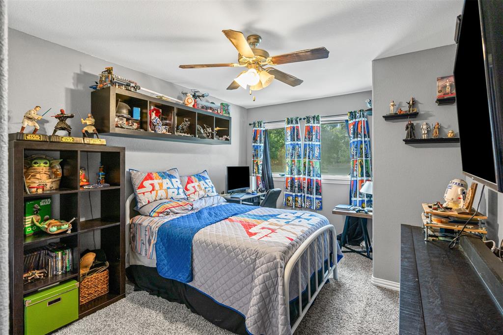 905 Poe Street Azle, TX 76020 - Photo 23 of 30 a bedroom that has a bed and a tv in it