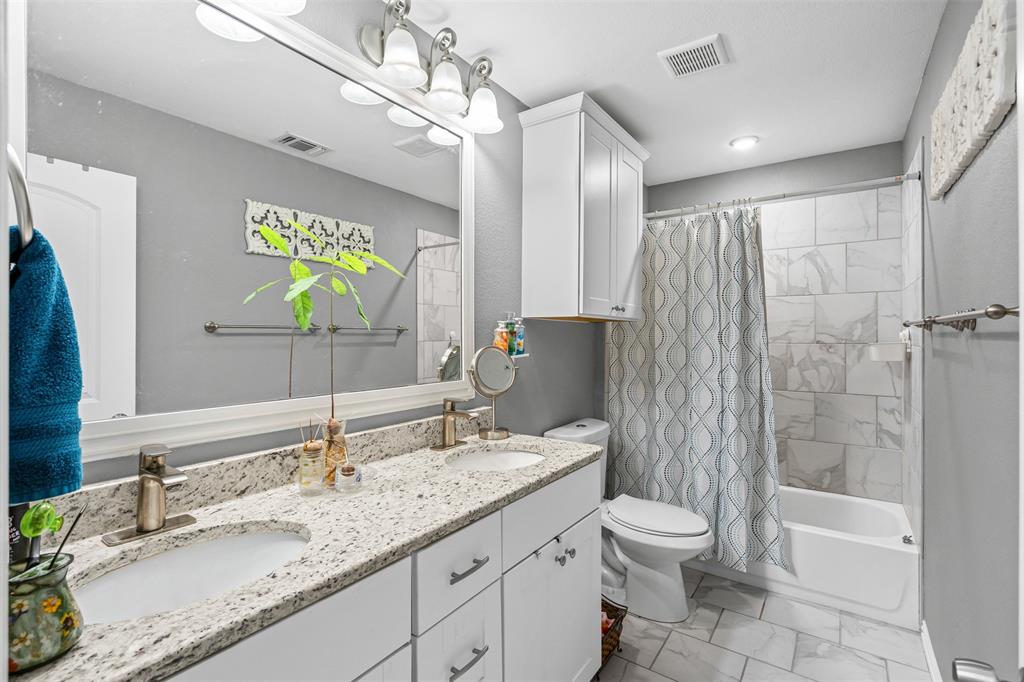 905 Poe Street Azle, TX 76020 - Photo 24 of 30 a bathroom with a granite countertop sink toilet and shower
