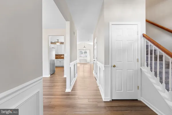 a view of a hallway with wooden floor and closet