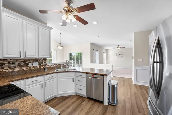 a kitchen with a sink a refrigerator and cabinets