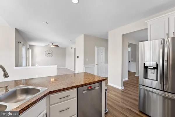 a kitchen with stainless steel appliances granite countertop a refrigerator and a sink
