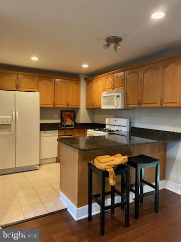 1200 South Arlington Ridge Road, Unit 411 Arlington, VA 22202 - Photo 2 of 9 a kitchen with stainless steel appliances granite countertop a refrigerator a sink a stove a dining table and chairs