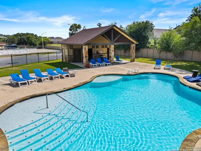 a view of a house with swimming pool and furniture