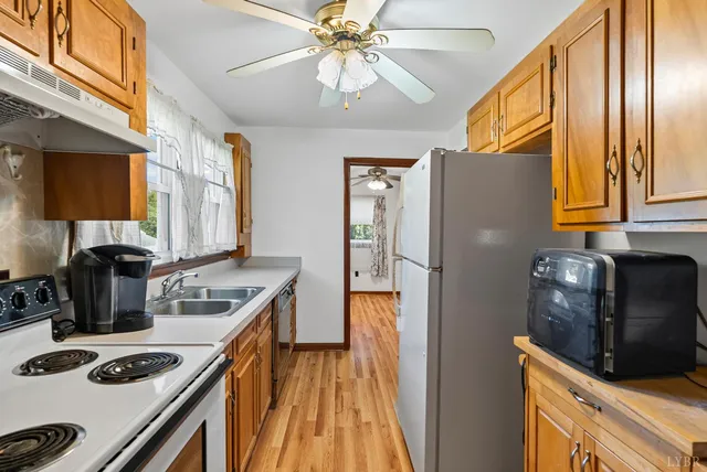 a kitchen with stainless steel appliances granite countertop a refrigerator a stove and a sink