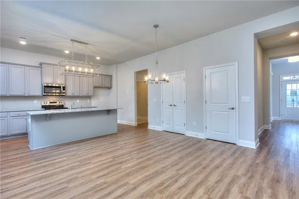 a view of kitchen with wooden floor and electronic appliances
