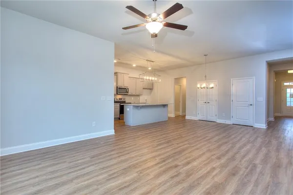 a view of an empty room with window and wooden floor