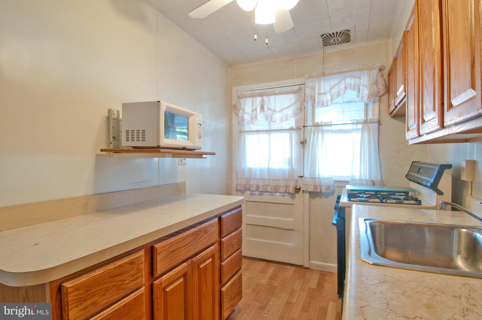 422 Westfield Road Baltimore, MD 21222 - Photo 6 of 24 a kitchen that has a sink a stove and wooden floor